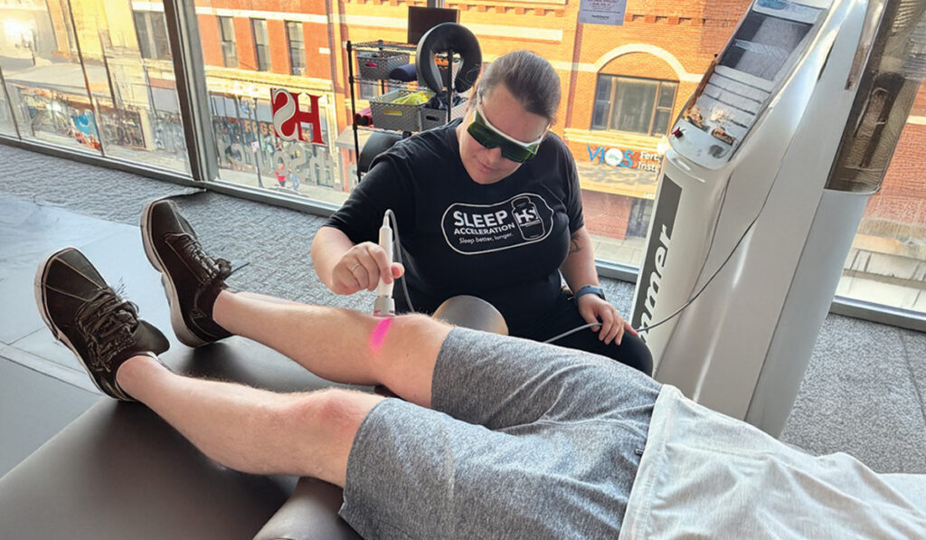 Dr. Katie Carlin performing Laser Therapy on a patient at HealthSource of Chicago-Wicker Park