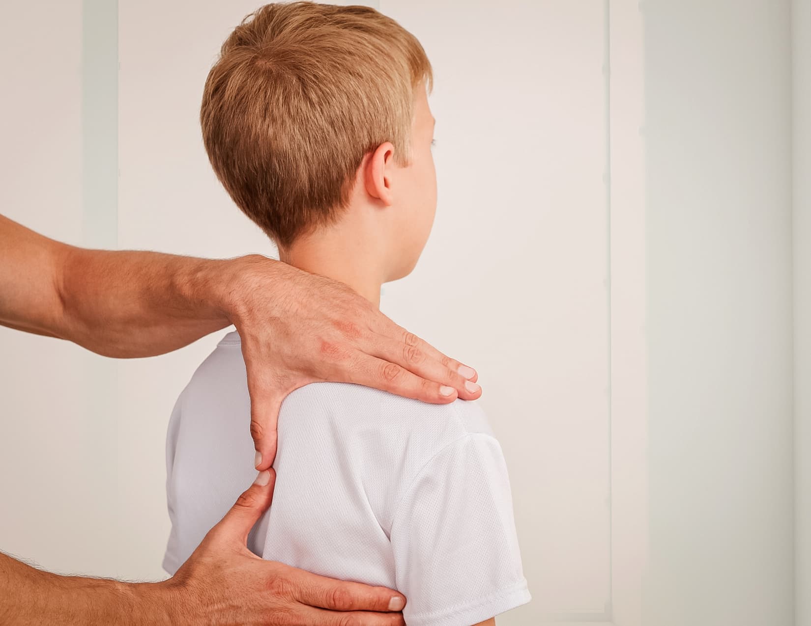 Close up of practitioner examining a child's right shoulder blade.