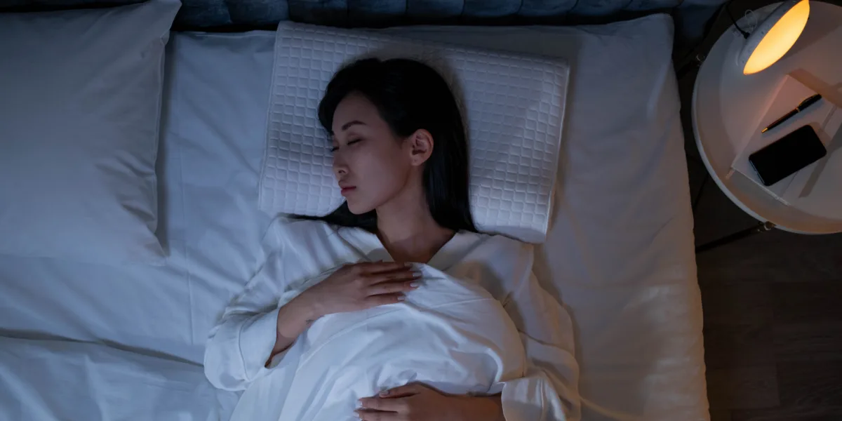 Woman sleeps in bed on a therapeutic pillow